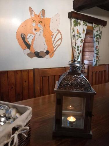 a lamp on a table with a fox painting on the wall at Chaloupka u lišáka in Sněžné