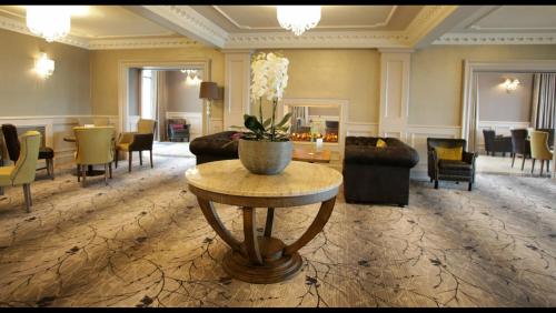 a large living room with a table and chairs at Royal Court Hotel in Portrush
