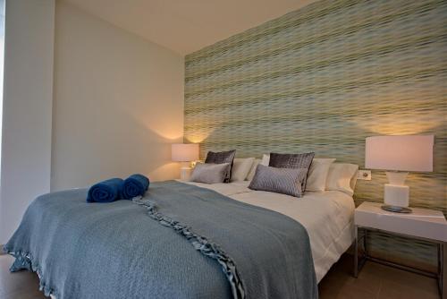 una camera da letto con un grande letto con cuscini blu di Villa Paradise a Playa Paraiso