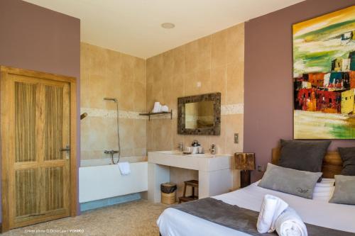 a bedroom with two beds and a sink and a bathtub at Hotel restaurant Spa Disini Montpellier Est, The Originals Relais in Castries