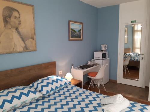 a bedroom with a bed and a desk with a microwave at Tajc Rooms in Split