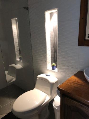 a bathroom with a toilet and a sink and a window at 40 Amigos Hotel in Jardin