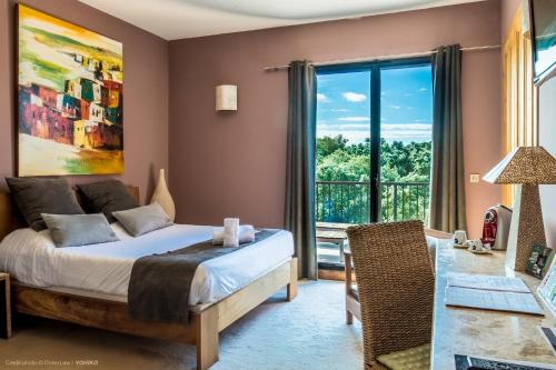ein Schlafzimmer mit einem Bett und einem Balkon in der Unterkunft Hôtel Disini Montpellier Est, The Originals Relais (Relais du Silence) in Castries