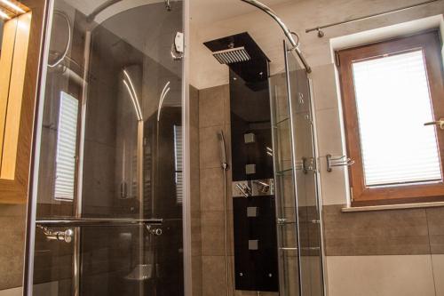 a shower with a glass door in a bathroom at Apartament Pod Modrzewiami in Szczawnica