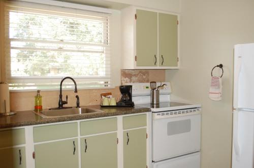 a kitchen with a sink and a white refrigerator at Trees Motel in Bishop