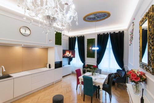 a living room with a table and chairs and a chandelier at Vogue apartment near by Wenceslas Square in Prague