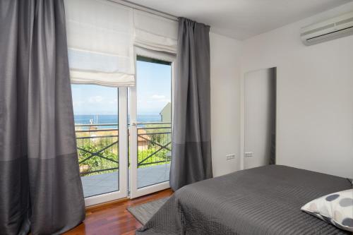 a bedroom with a bed and a large window at Apartments Biba in Malinska