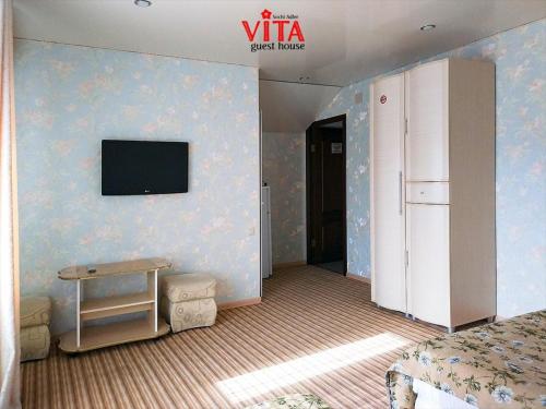 アドレルにあるVitaの白い冷蔵庫、壁にテレビが備わるベッドルーム1室が備わります。