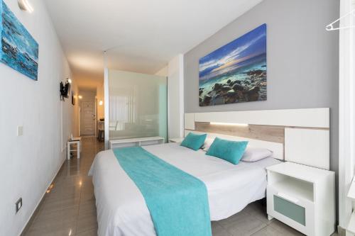 ラスパルマス・デ・グランカナリアにある1st Line Studio Las Canteras Beach - Wifiのベッドルーム(青い枕の大きな白いベッド付)