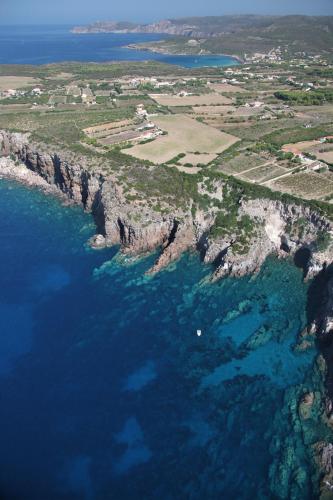 an aerial view of the ocean and a rocky coastline at Guardia dei Mori in Carloforte