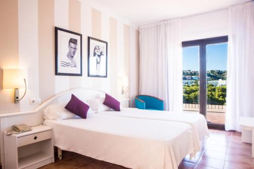 a bedroom with two beds and a large window at Hotel Boutique Bon Repos - Adults Only in Santa Ponsa