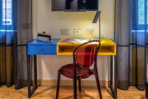 a yellow desk with a chair and a blue desk at Albergo Etico Roma in Rome