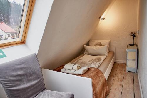 a small bed in a small room with a window at Holzwerk Oybin in Kurort Oybin