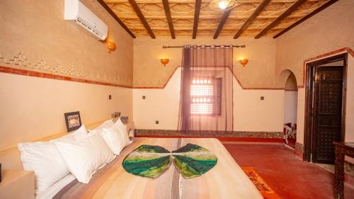 a bedroom with a bed with a bow tie on it at Ecolodge l'île de Ouarzazate in Ouarzazate