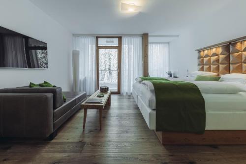 a bedroom with a large bed and a couch at Mooser Hotel in Sankt Anton am Arlberg
