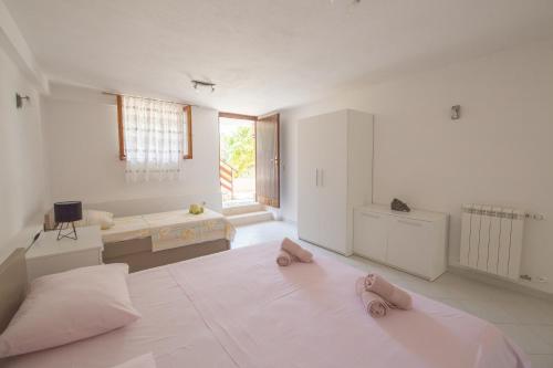 Duży, biały pokój z łóżkiem i kapciami. w obiekcie Adria w Slatine