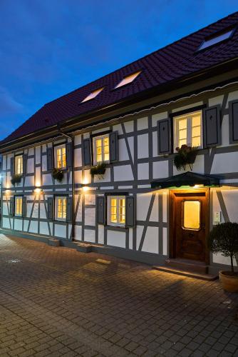 a white and black building with lights on at Die Grüne Bettlad Boutique-Hotel in Bühl