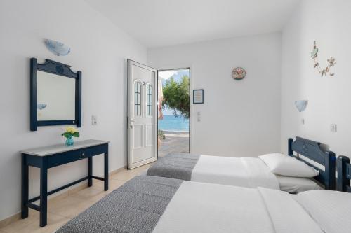 een slaapkamer met een bed, een tafel en een deur bij Kozas Superior Apartments in Archangelos