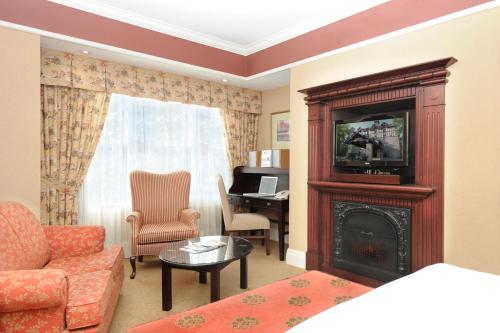a living room with a fireplace and a television at Old Mill Toronto Hotel in Toronto