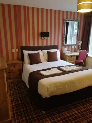a hotel room with a large bed and a desk at The Trafford Hotel in Blackpool