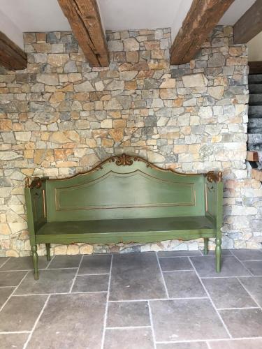 a green bench sitting against a stone wall at Die Grüne Bettlad Boutique-Hotel in Bühl