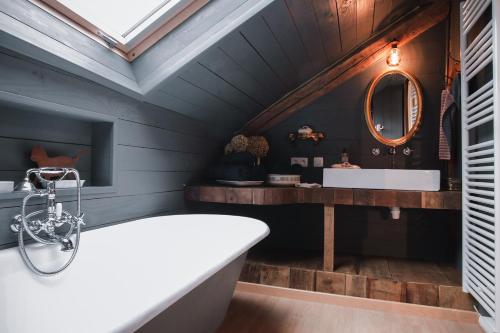 Sainte-CécileにあるLes Chambres du Chatの白い浴槽と鏡のあるバスルーム