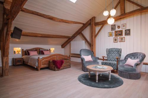 Sainte-CécileにあるLes Chambres du Chatのベッドルーム1室(ベッド1台、椅子2脚、テーブル付)