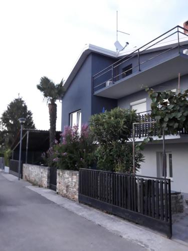 a blue and white house with a fence at B&B Villa Vela in Umag