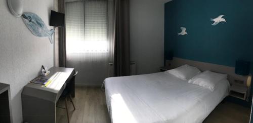 a bedroom with a white bed and a desk and a window at Les Jardins d'Oléron in Saint-Pierre-dʼOléron