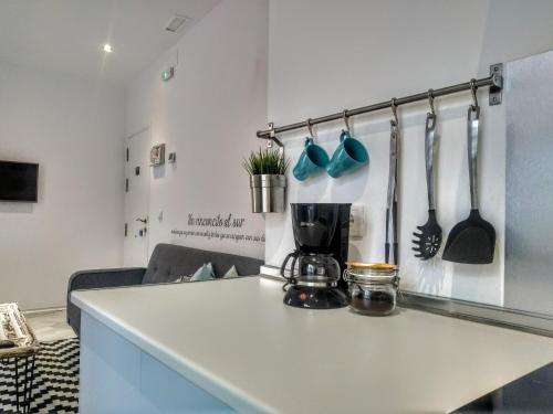 a kitchen counter with a coffee maker and utensils at Apartamentos GADIR CENTRO in Cádiz