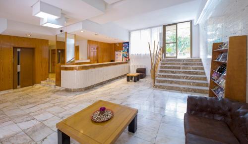 a living room with a table and a staircase at Apartamentos Jovial in San Antonio
