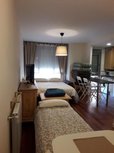 a bedroom with two beds and a living room at Apartamento en c/ Peroneros in Latas