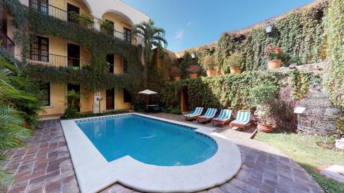 a swimming pool in front of a building at Hotel Boutique La Mision De Fray Diego in Mérida