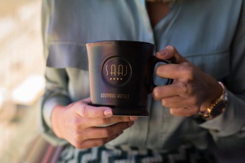 a person holding a coffee cup in their hands at Silken Saaj Las Palmas in Las Palmas de Gran Canaria