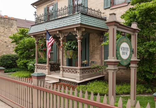 una casa con una valla y una bandera americana en Washington House Inn, en Cedarburg