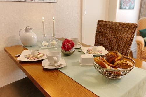 a table with a bowl of bread and candles on it at FeWo Hage in Langelsheim