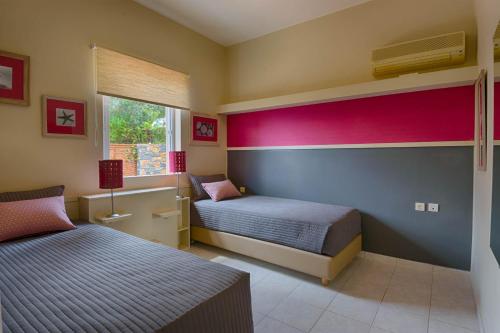 a bedroom with two beds and a window at Villa Sophia in Agios Nikolaos