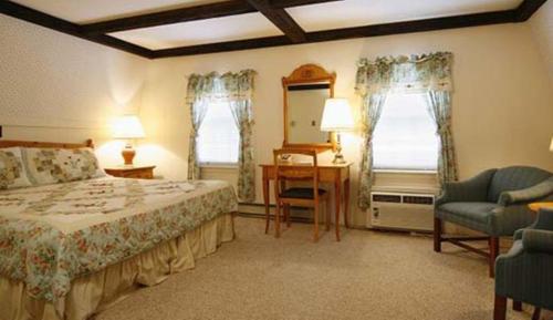 a bedroom with a bed and a desk and a chair at Old Field House in North Conway