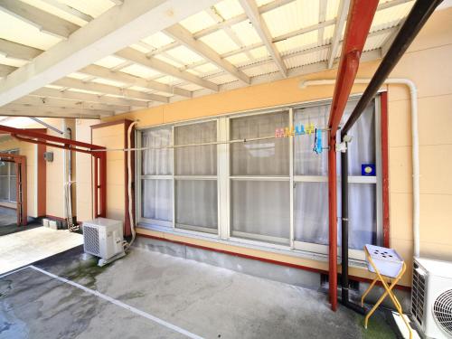 an empty room with large windows in a building at カモンイン 寿 in Izumi