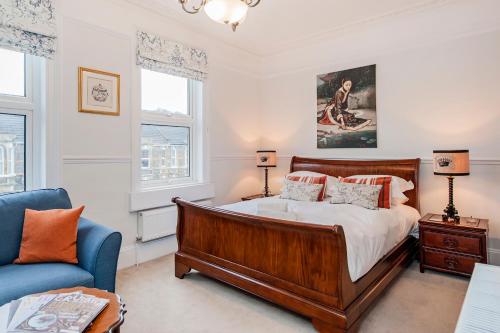 a bedroom with a bed and a blue couch at Apple Tree boutique B&B in Bath