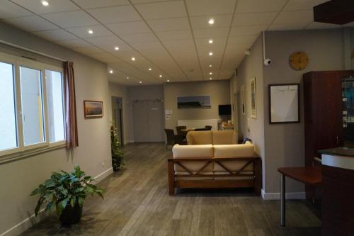 an office with a waiting room with a couch and a table at Hôtel & Restaurant des Remparts in Rochefort