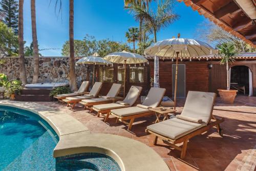 a row of lounge chairs next to a swimming pool at Finca Santa Maria in Callao Salvaje