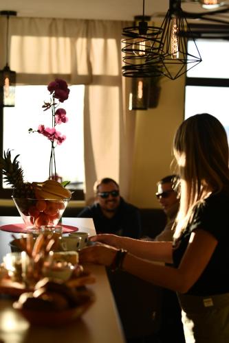 a woman standing at a table with a plate of food at Apartman D52 Dvori in Kopaonik