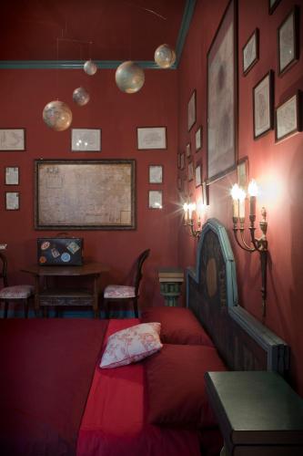 a bedroom with red walls and a bed and a table at Repubblica Di Oz Rooms in Varese