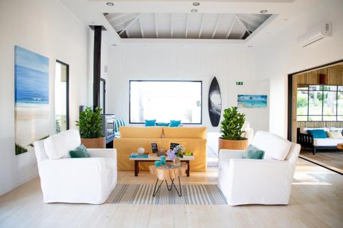 a living room with two white chairs and a table at Casa Flor in Punta del Este