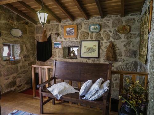 a room with a bench in a stone wall at Casa Das Videiras in Soajo