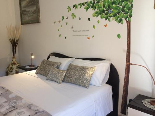 ein Schlafzimmer mit einem Bett mit Blättern an der Wand in der Unterkunft La Dimora di Paola in Lecce