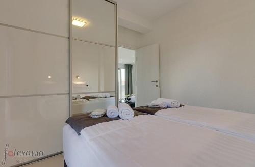 1 dormitorio con 2 camas y un espejo grande en Villa Christina en Crikvenica