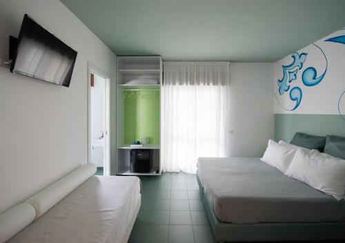 a hotel room with two beds and a window at Oikos Selinunte Guest House in Marinella di Selinunte