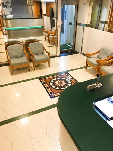 a lobby with chairs and a table and a counter at Holiday Guest House in Hong Kong